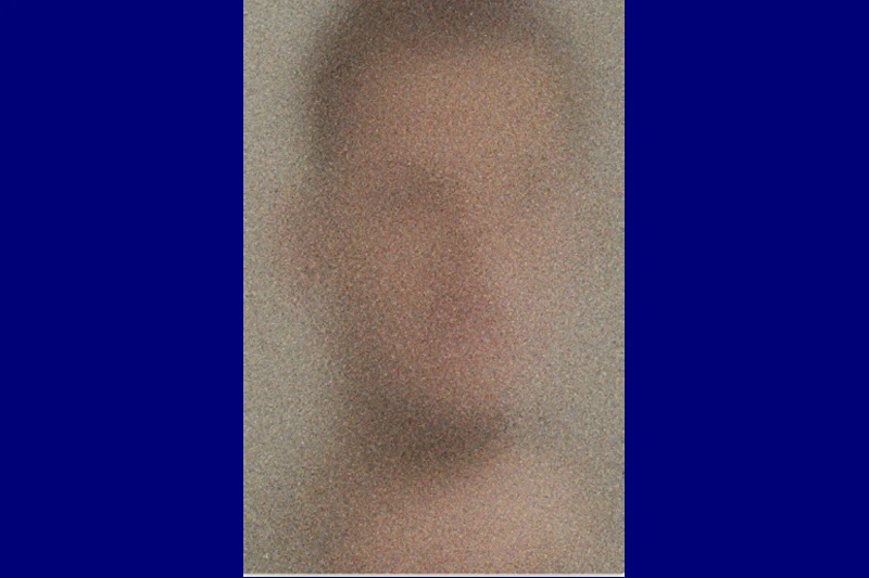 Blurred and pixelated image of a human face with muted colors.