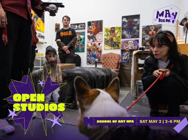 Indoor art studio with people, a dog, a marionette puppet, and colorful artwork on the walls.